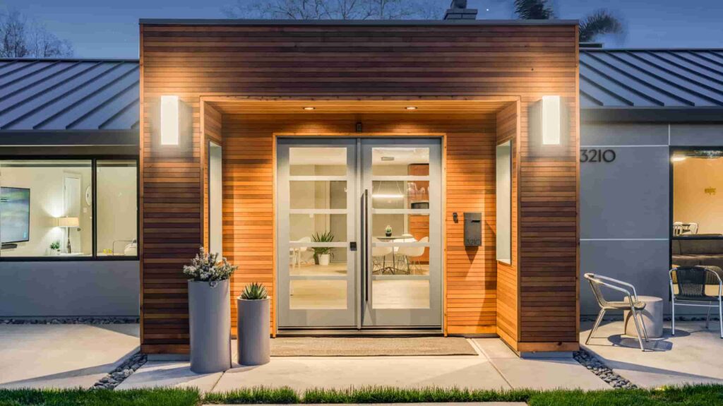 front view of a grey house with wooden entryway