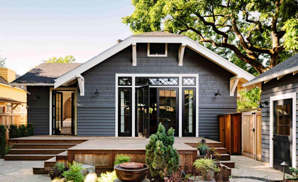 front view of a dark grey house with white cedar on windows and porch