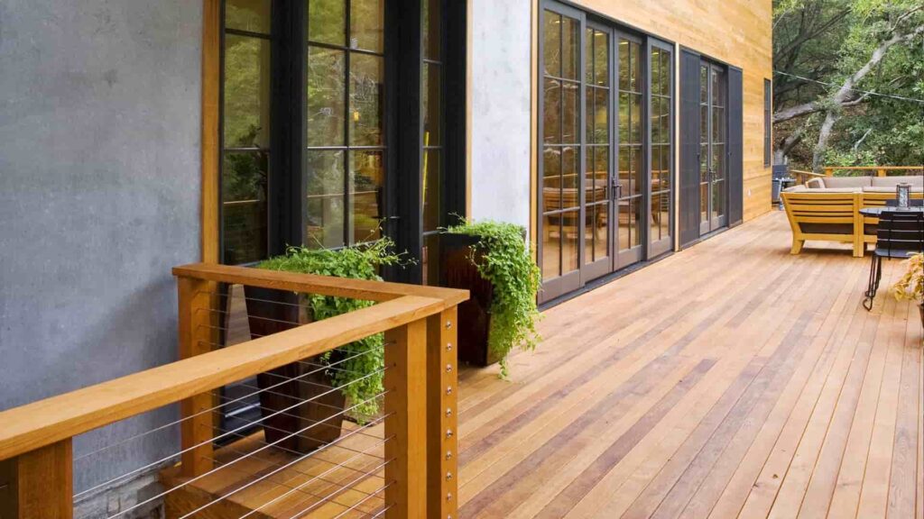 side view of a grey painted house with wooden deck