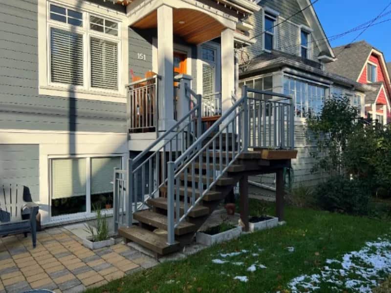 grey house with cedar exterior stairs