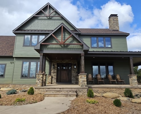 an image of a sage green house with black trim accents