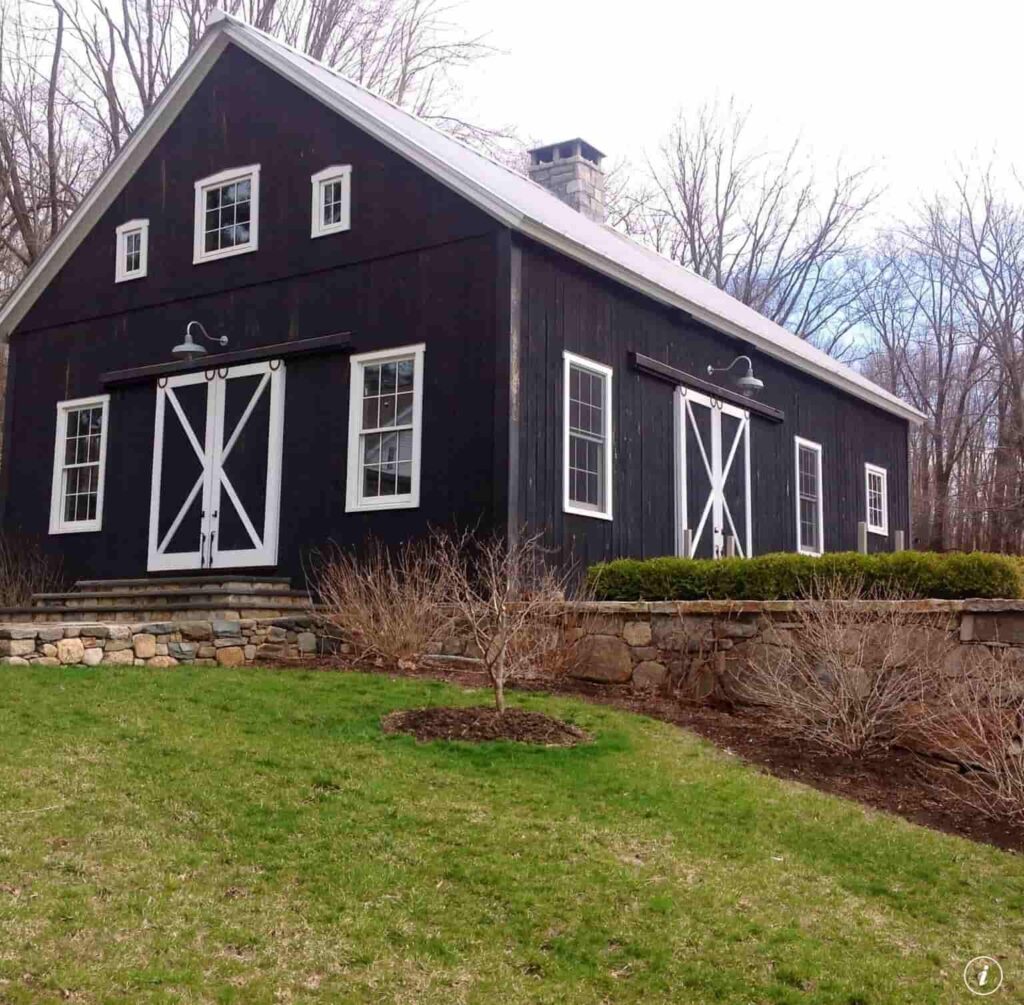 a black barndominium house with white trim