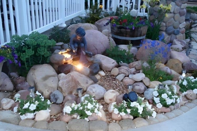 an image with a corner rock garden with flower succulents and mix of big and small rocks