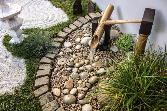 an image of a small corner rock garden with pebble rocks and sand