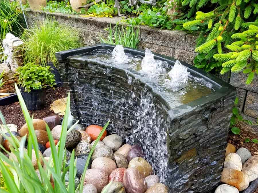 an image of a small water feature in an fairytale inspired english cottage garden