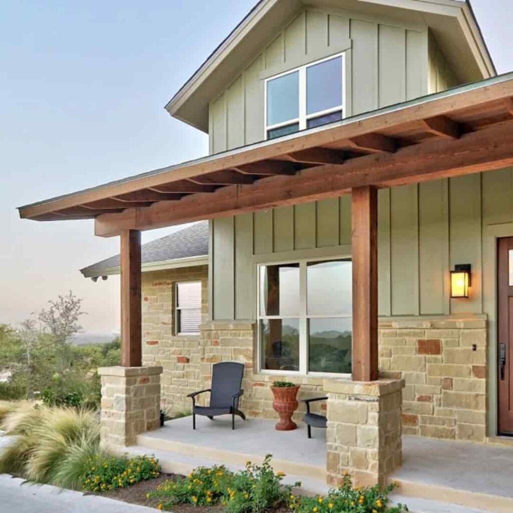 an image of a sage green house with wooden porch