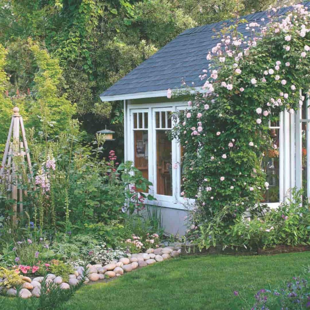 an image of a beautiful white shed in a farytale english cottage garden