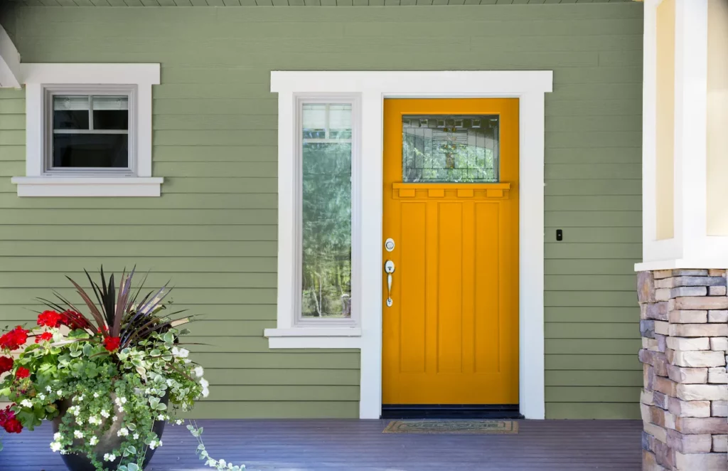an image showing Exterior Sage Green House with with Warm Mustard Yellow Front Door