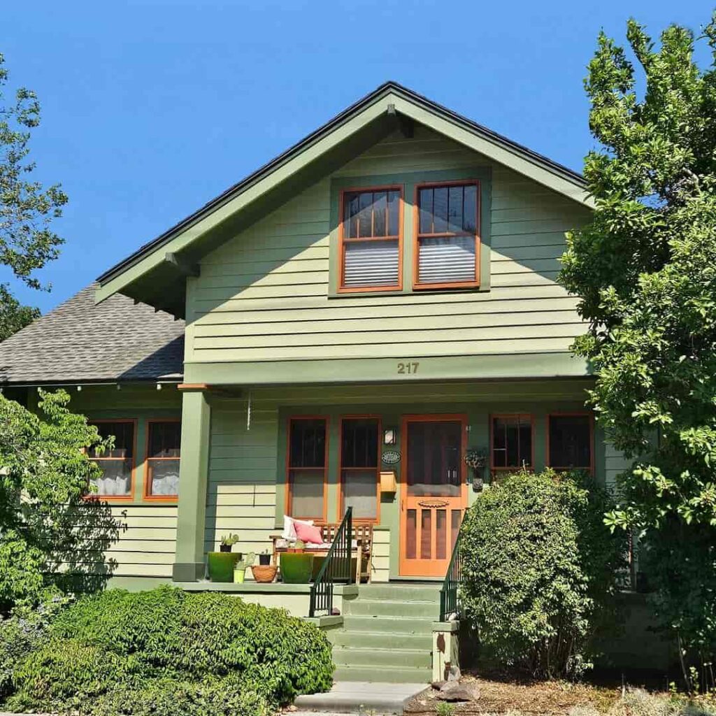 Sage green house exterior with earthy accent front door