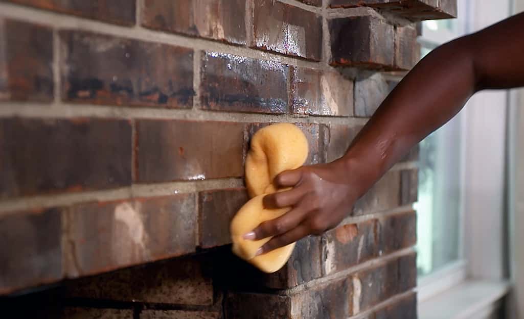 cleaning the dirty and dusty fireplace bricks