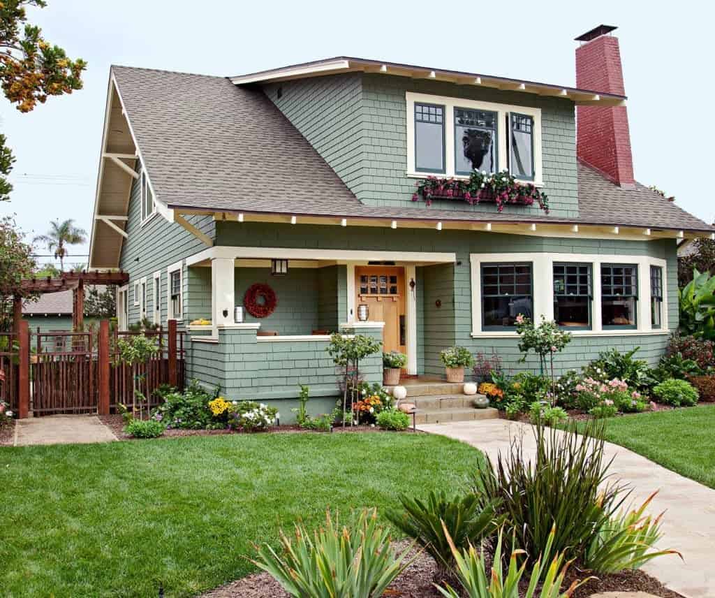2 story sage green house with black roof and white windows
