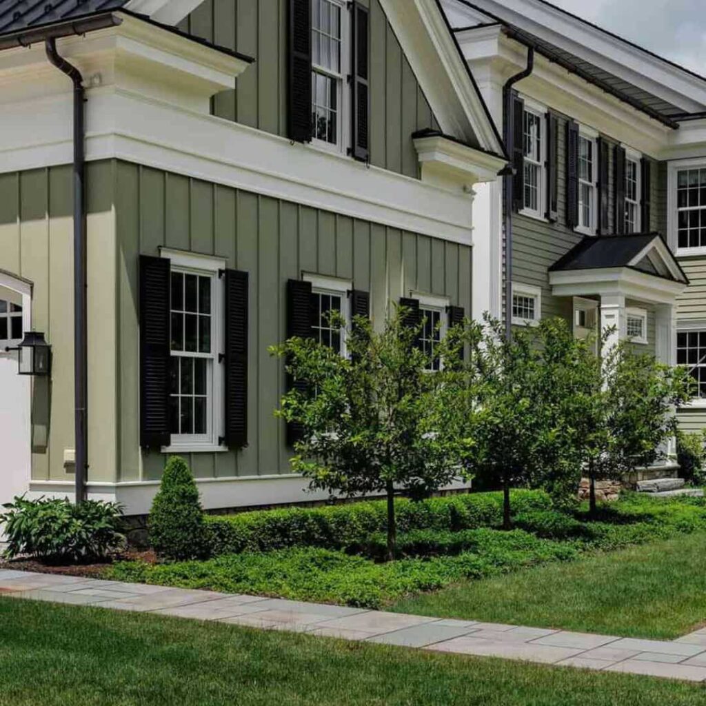 an image of a colonial styled sage green house with black accent