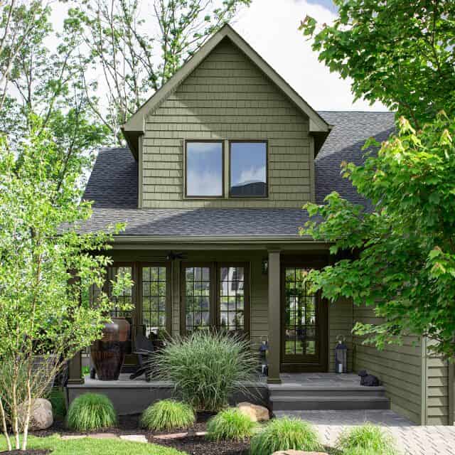 an image of a sage green farmhouse with black accent