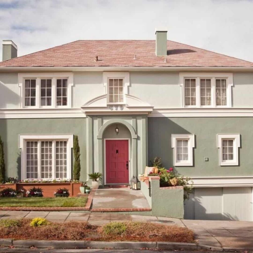 an image of a sage green house with orange, white, and black accents
