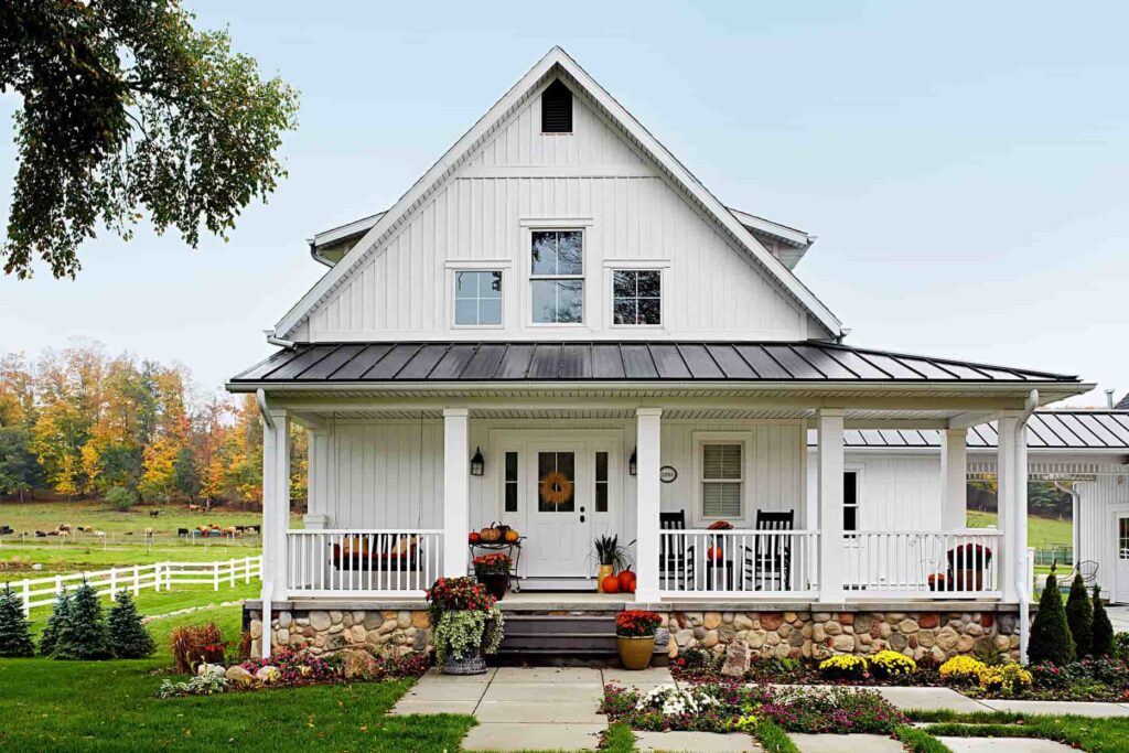 a front view of a white and black barndominum house with a white classy porch