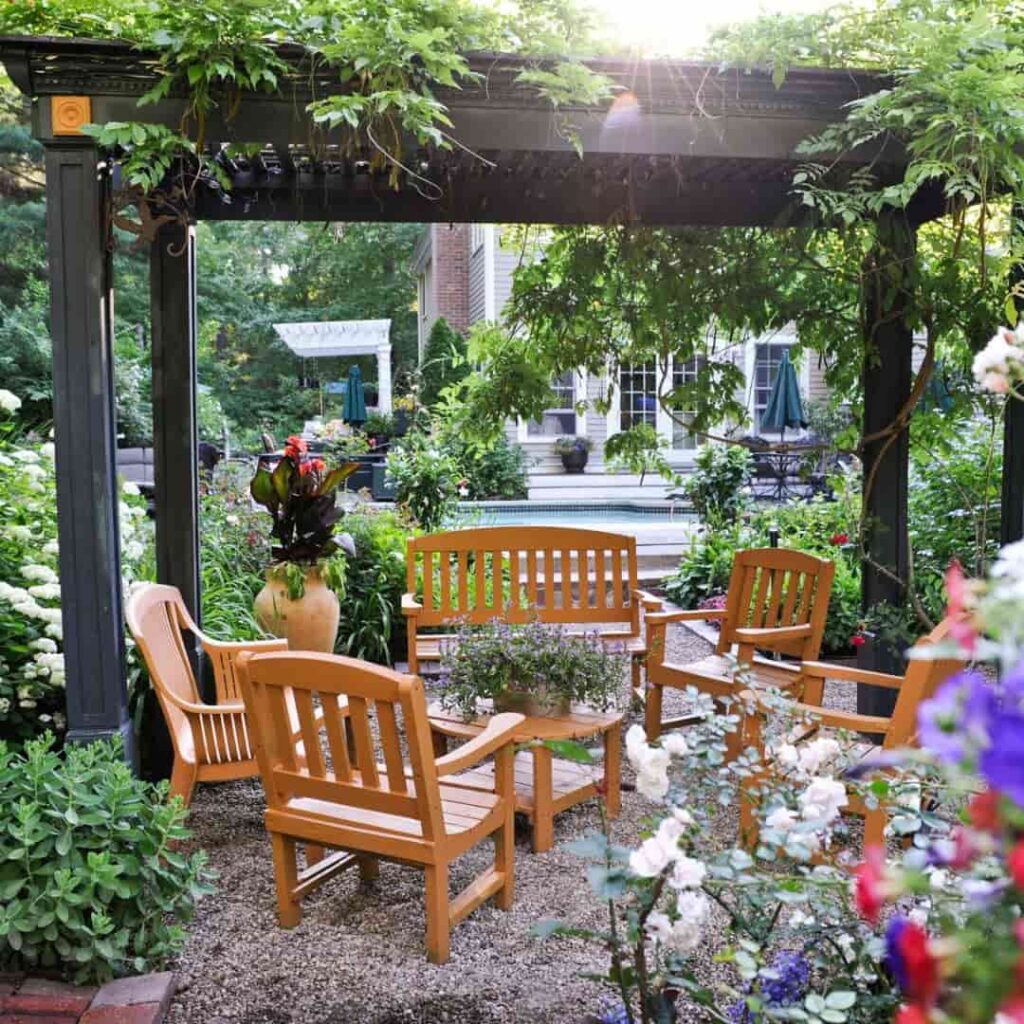 an image of a beautiful wooden seating arrangement under a black pergola