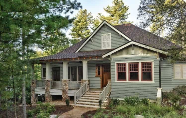 an image of a Sage green house with black roof and brown window trims