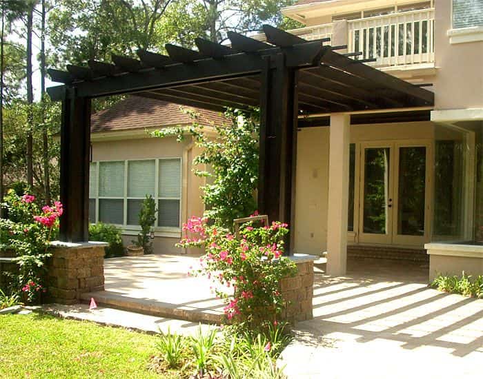 an image of a Tan house with black pergola