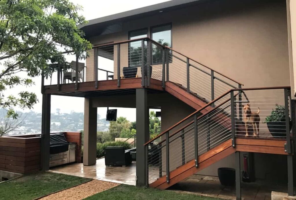 an image of a Tan house with black trim and black railings